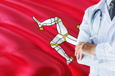 Doctor standing with stethoscope on Isle Of Man flag background. National healthcare system concept, medical theme.の写真素材