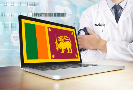 Sri Lanka healthcare system in tech theme. Sri Lankan flag on computer screen. Doctor standing with stethoscope in hospital. Cryptocurrency and Blockchain concept.の写真素材