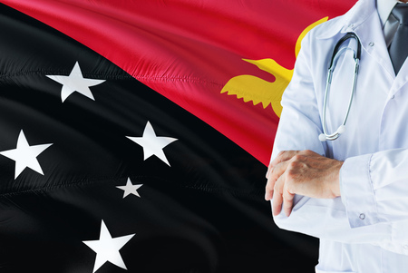 Doctor standing with stethoscope on Papua New Guinea flag background. National healthcare system concept, medical theme.の写真素材