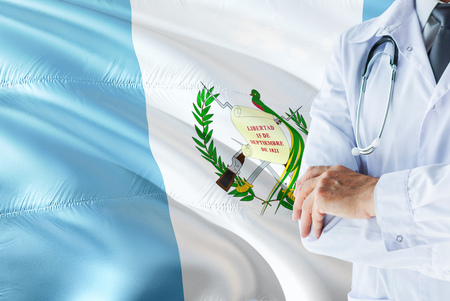 Guatemalan Doctor standing with stethoscope on Guatemala flag background. National healthcare system concept, medical theme.の写真素材