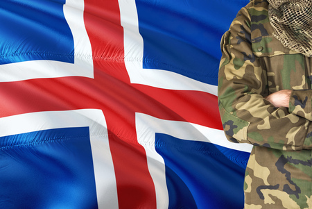 Crossed arms soldier with national waving flag on background - Iceland Military theme.の写真素材