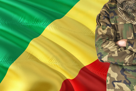 Crossed arms soldier with national waving flag on background - Republic Of The Congo Military theme.の写真素材