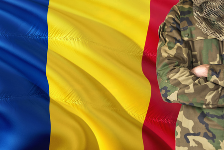 Crossed arms Romanian soldier with national waving flag on background - Romania Military theme.の写真素材
