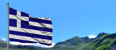 Greece flag waving in the blue sky with green fields at mountain peak background. Nature theme.の写真素材