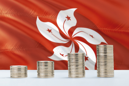 Hong Kong flag waving in the background with rows of coins for finance and business concept. Saving money.の写真素材