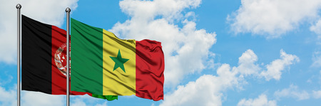 Afghanistan and Senegal flag waving in the wind against white cloudy blue sky together. Diplomacy concept, international relations.の写真素材