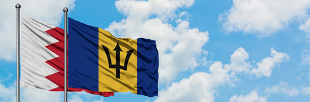 Bahrain and Barbados flag waving in the wind against white cloudy blue sky together. Diplomacy concept, international relations.の写真素材