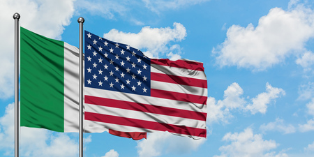 Italy and United States flag waving in the wind against white cloudy blue sky together. Diplomacy concept, international relations.の写真素材
