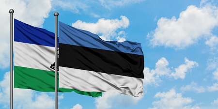 Lesotho and Estonia flag waving in the wind against white cloudy blue sky together. Diplomacy concept, international relations.の写真素材