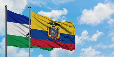 Lesotho and Ecuador flag waving in the wind against white cloudy blue sky together. Diplomacy concept, international relations.の写真素材