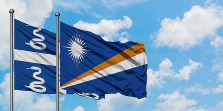 Martinique and Marshall Islands flag waving in the wind against white cloudy blue sky together. Diplomacy concept, international relations.の写真素材