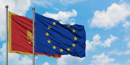 Montenegro and European Union flag waving in the wind against white cloudy blue sky together. Diplomacy concept, international relations.の写真素材