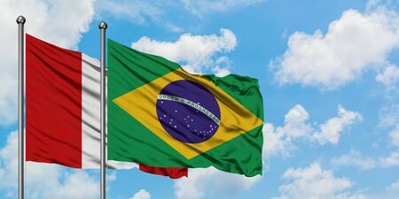 Peru and Brazil flag waving in the wind against white cloudy blue sky together. Diplomacy concept, international relations.の写真素材