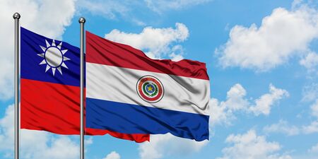 Taiwan and Paraguay flag waving in the wind against white cloudy blue sky together. Diplomacy concept, international relations.の写真素材