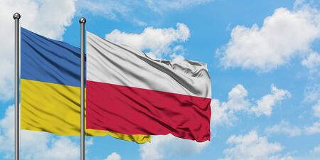 Ukraine and Poland flag waving in the wind against white cloudy blue sky together. Diplomacy concept, international relations.の写真素材