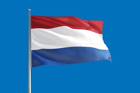 Netherlands national flag waving in the wind on a deep blue sky. High quality fabric. International relations concept.の写真素材