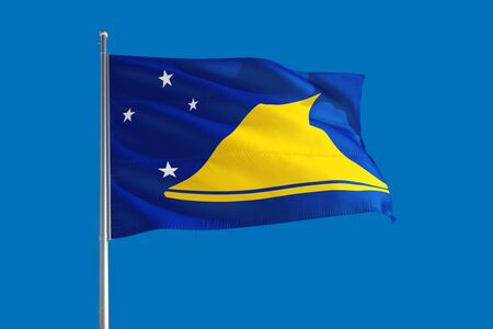 Tokelau national flag waving in the wind on a deep blue sky. High quality fabric. International relations concept.の写真素材