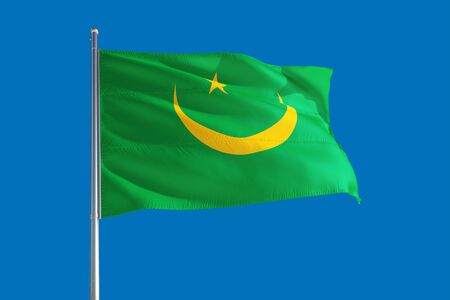 Mauritania national flag waving in the wind on a deep blue sky. High quality fabric. International relations concept.の写真素材