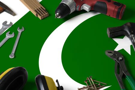 Pakistan flag on repair tool concept wooden table background. Mechanical service theme with national...