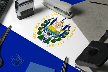 El Salvador flag with office clerk workplace background. National stationary concept with office tools.の写真素材