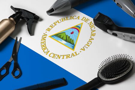 Nicaragua flag with hair cutting tools. Combs, scissors and hairdressing tools in a beauty salon...