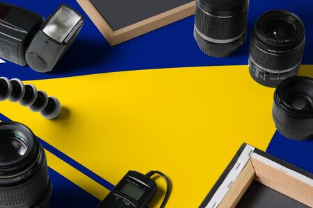 Tokelau national flag with top view of personal photographer equipment and tools on white wooden...