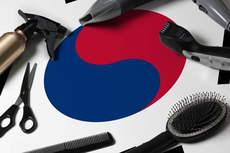 South Korea flag with hair cutting tools. Combs, scissors and hairdressing tools in a beauty salon desktop on a national wooden background.の写真素材