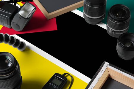 Mozambique national flag with top view of personal photographer equipment and tools on white wooden table, copy space.の写真素材