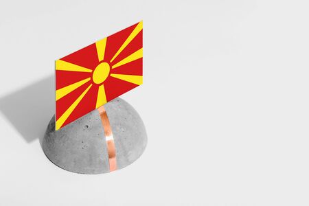 Macedonia flag tagged on rounded stone. White isolated background. Side view minimal national concept.の写真素材