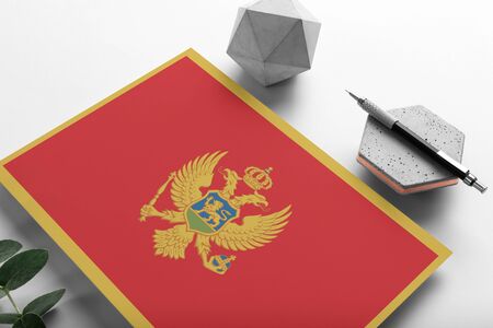 Montenegro flag on minimalist paper background. National invitation letter with stylish pen on stone. Communication concept.の写真素材