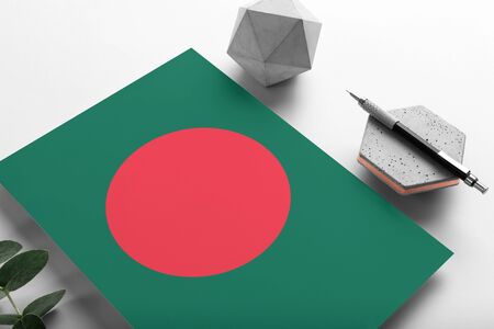 Bangladesh flag on minimalist paper background. National invitation letter with stylish pen on stone. Communication concept.の写真素材