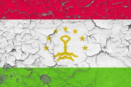 Tajikistan flag close up grungy, damaged and weathered on wall peeling off paint to see inside surface. Vintage concept.の写真素材