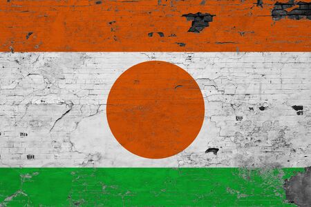 Niger flag on grunge scratched concrete surface. National vintage background. Retro wall concept.の写真素材