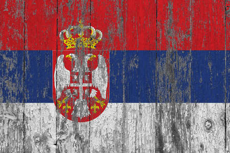 Serbia flag on grunge scratched wooden surface. National vintage background. Old wooden table scratched flag surface.の写真素材