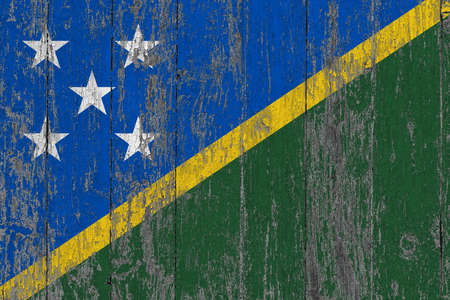 Solomon Islands flag on grunge scratched wooden surface. National vintage background. Old wooden table scratched flag surface.の写真素材