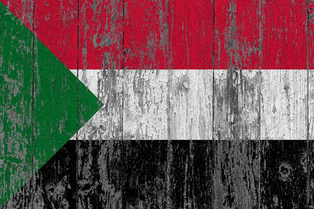 Sudan flag on grunge scratched wooden surface. National vintage background. Old wooden table scratched flag surface.の写真素材