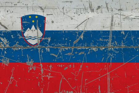Slovenia flag painted on cracked dirty surface. National pattern on vintage style surface. Scratched and weathered concept.の写真素材