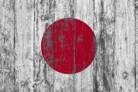 Japan flag on grunge scratched wooden surface. National vintage background. Old wooden table scratched flag surface.の写真素材