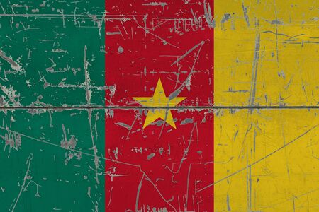 Cameroon flag painted on cracked dirty surface. National pattern on vintage style surface. Scratched and weathered concept.の写真素材