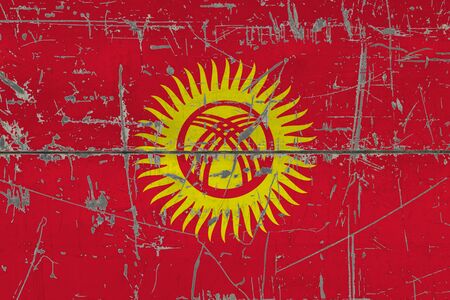 Kyrgyzstan flag painted on cracked dirty surface. National pattern on vintage style surface. Scratched and weathered concept.の写真素材