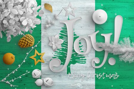 Norfolk Island flag on wooden table with joy text. Christmas and new year background, celebration national concept with white decor.の写真素材