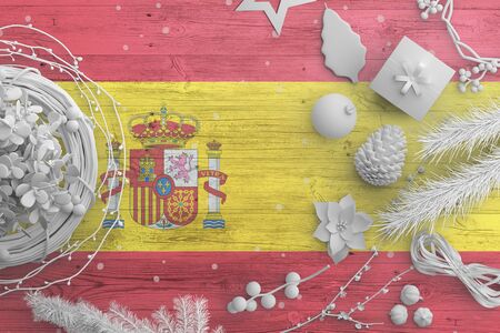 Spain flag on wooden table with snow objects. Christmas and new year background, celebration national concept with white decor.の写真素材