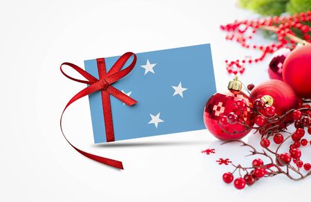 Micronesia flag on new year invitation card with red christmas ornaments concept. National happy new year composition.の写真素材