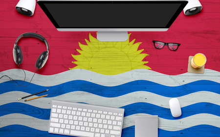Kiribati flag background with headphone,computer keyboard and mouse on national office desk table.Top view with copy space.Flat Lay.の写真素材