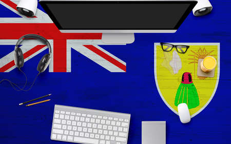 Turks And Caicos Islands flag background with headphone,computer keyboard and mouse on national office desk table.Top view with copy space.Flat Lay.の写真素材