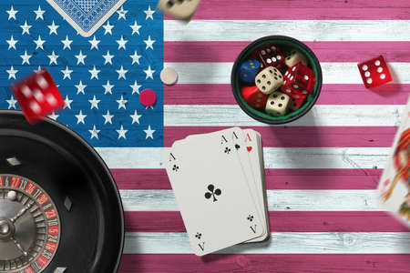 United States casino theme. Aces in poker game, cards and chips on red table with national flag...