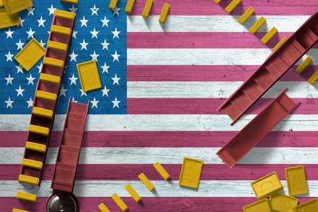 United States flag with national background with dominoes on wooden table. Top view. Concept of game.の写真素材