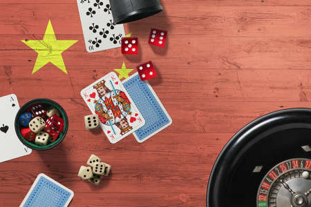 China casino theme. Aces in poker game, cards and chips on red table with national wooden flag background. Gambling and betting.の写真素材