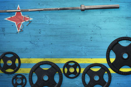 Aruba gym concept. Top view of heavy weight plates with iron bar on national background.の写真素材
