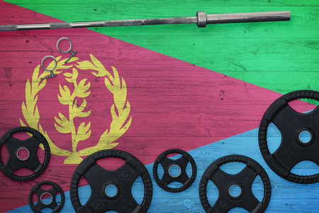 Eritrea gym concept. Top view of heavy weight plates with iron bar on national background.の写真素材